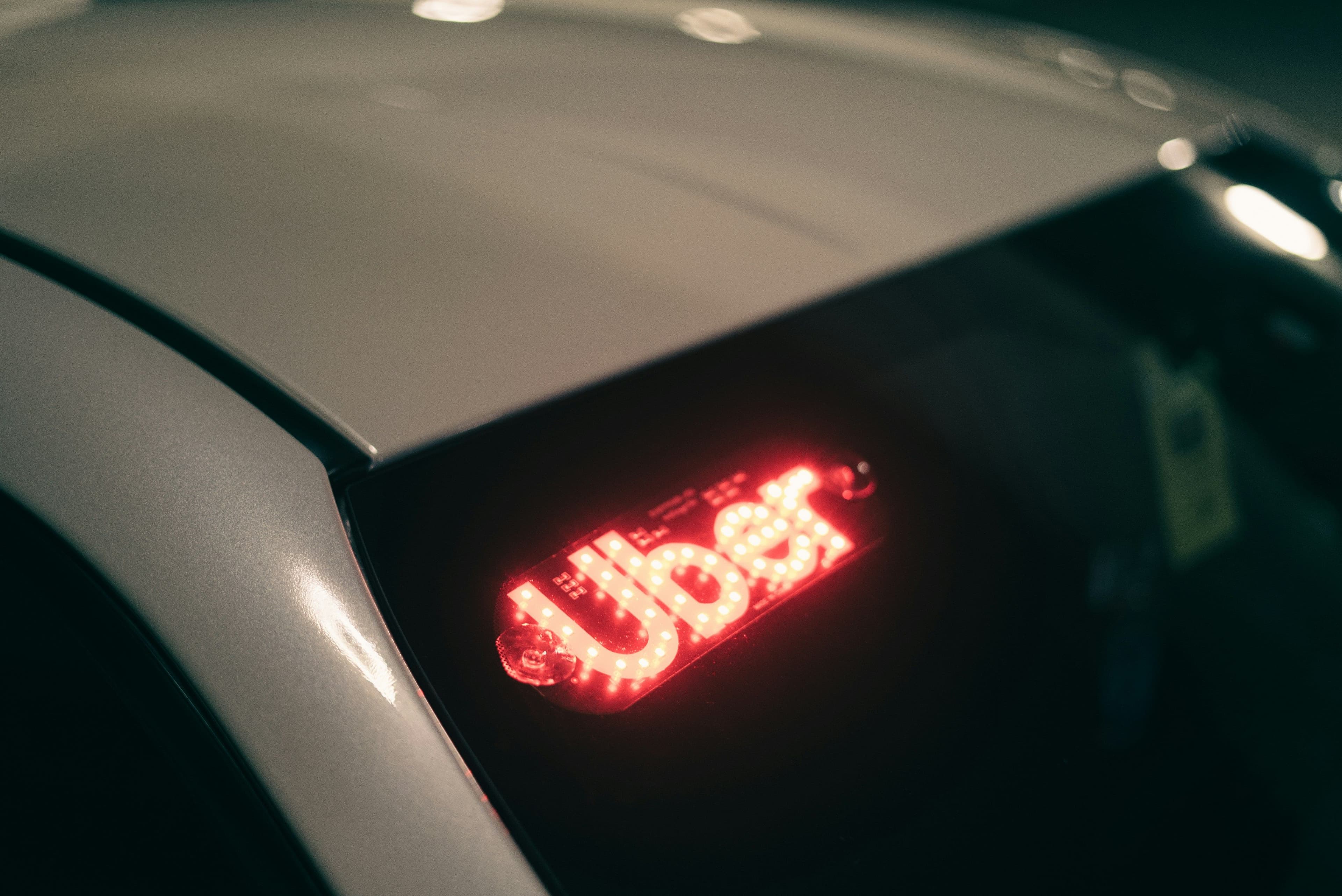 Close up of a car's tail lights reading 'Uber'