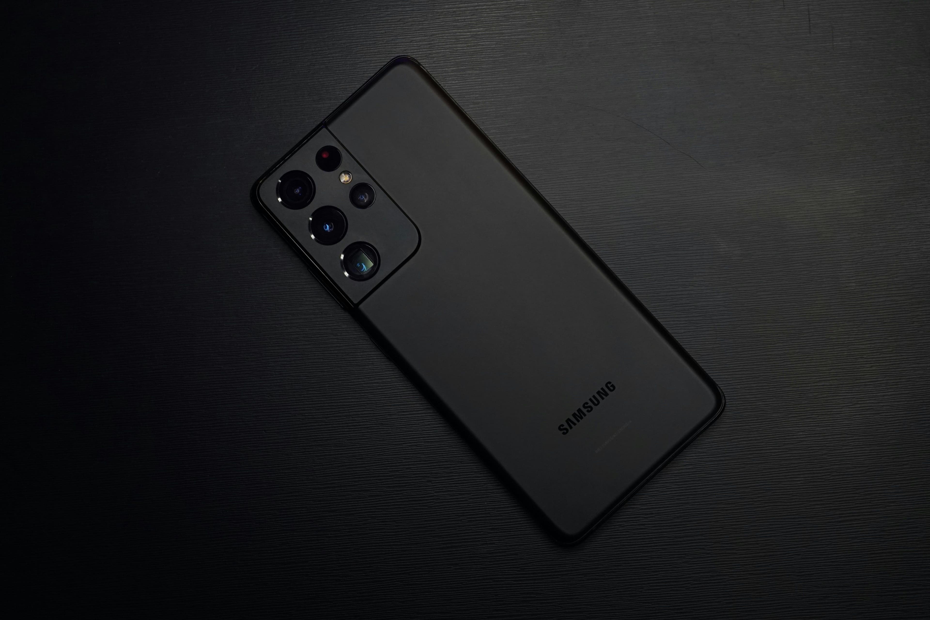 Main Image: Black Samsung Galaxy S21 on a black surface